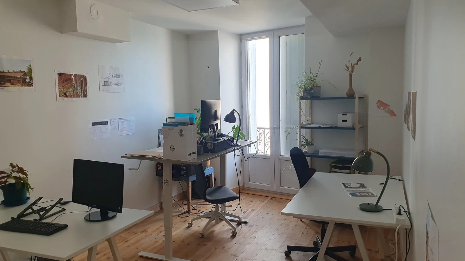 Un bureau partagé lumineux à l'étage du 59, avec parquet et grande fenêtre