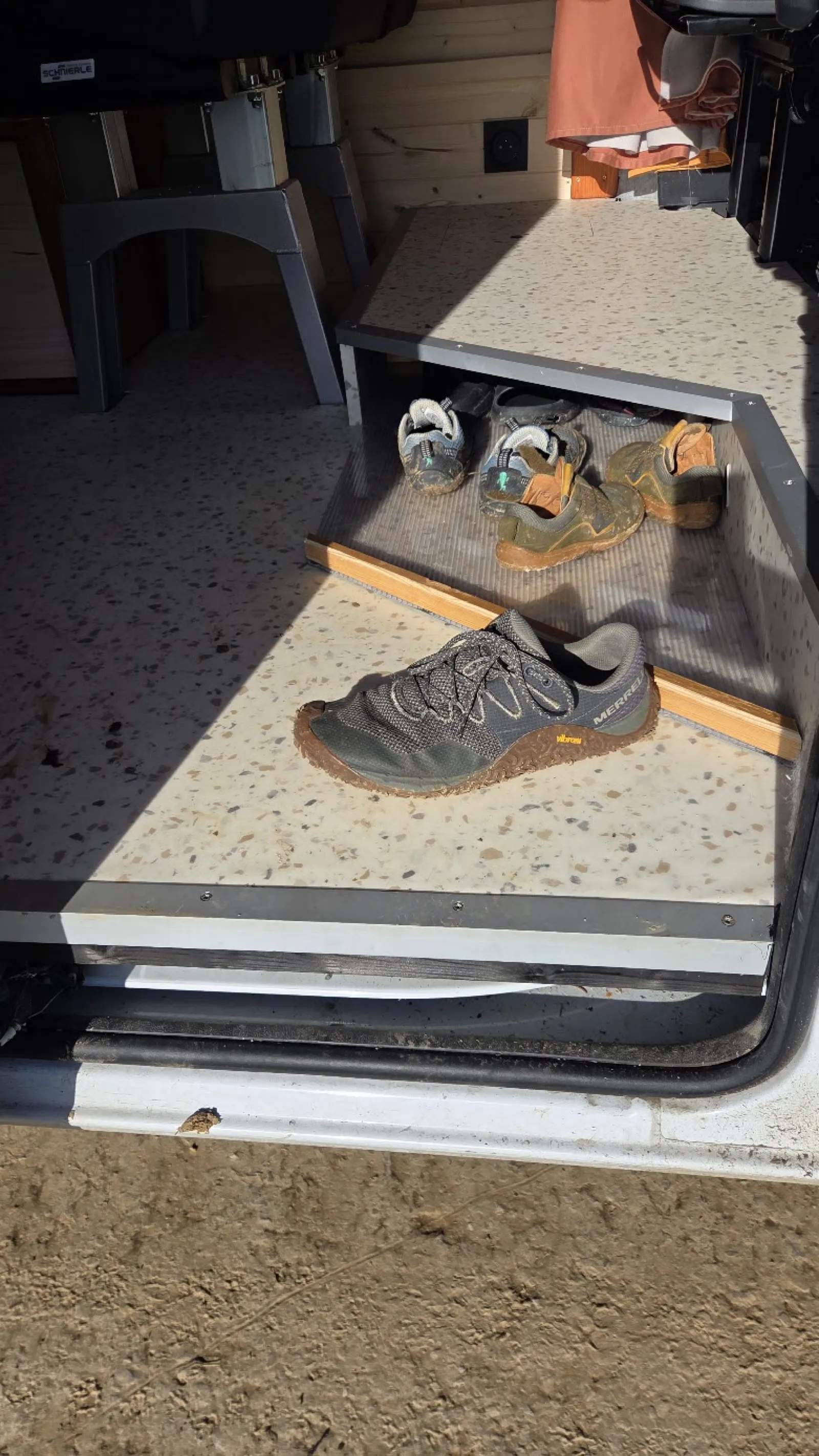 Rangement chaussures sous l'estrade du van